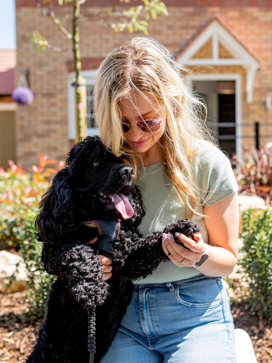 Lady and dog in front of house