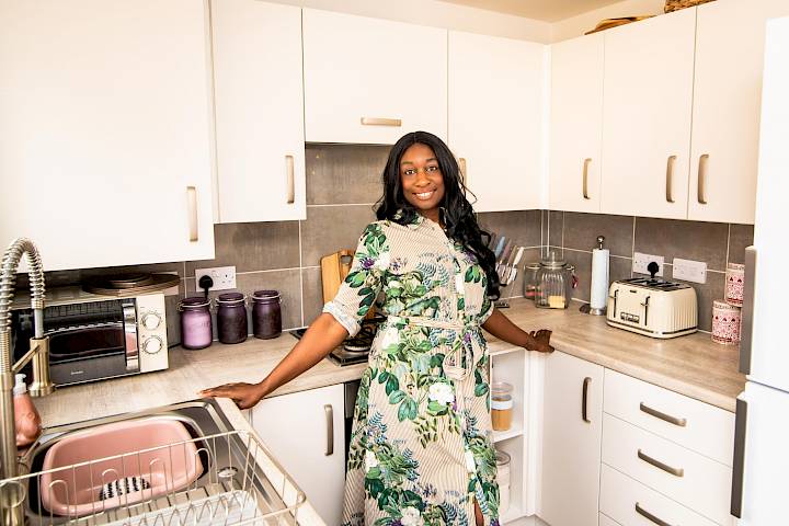 Woman stood in new kitchen.