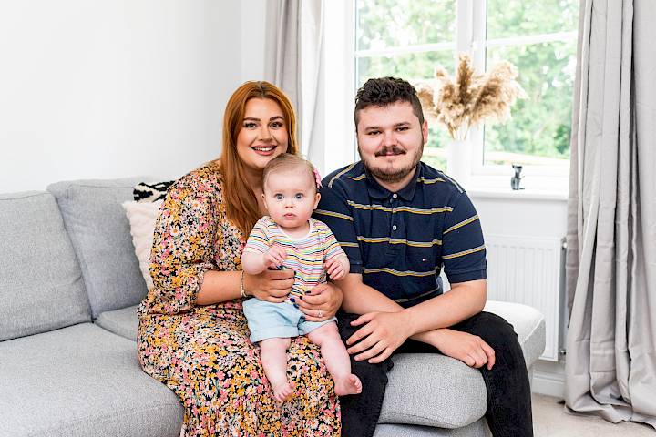 Happy family sat in new lounge.